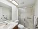 Bathroom featuring a framed sliding glass shower door, skylight, toilet, and countertop sink and mirror at 2009 Hammock Pine Blvd # 2009, Clearwater, FL 33761