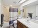 Bathroom featuring a shower-tub, toilet, sink, and large mirror with natural light from the ceiling at 2009 Hammock Pine Blvd # 2009, Clearwater, FL 33761