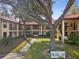 Exterior view of a two-story condo building with a well-maintained lawn and mature trees at 2009 Hammock Pine Blvd # 2009, Clearwater, FL 33761