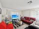 Bright living room with a comfortable red couch, a large TV, and modern decor at 2009 Hammock Pine Blvd # 2009, Clearwater, FL 33761