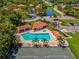 Aerial view of the community pool area with lounge chairs and a tennis court at 2009 Hammock Pine Blvd # 2009, Clearwater, FL 33761