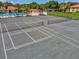 Aerial view of tennis courts, showing the court layout with the community pool in the background at 2009 Hammock Pine Blvd # 2009, Clearwater, FL 33761