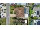 Aerial view of the home with a screened-in pool area, surrounded by lush landscaping and a brick-paved driveway at 2037 Church Creek Pt, Largo, FL 33774