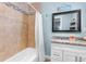 Bathroom featuring tiled shower-tub, single vanity, and stylish decorative accents at 2037 Church Creek Pt, Largo, FL 33774