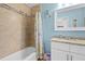 Bathroom featuring tiled shower-tub, single vanity, and stylish decorative accents at 2037 Church Creek Pt, Largo, FL 33774