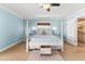 Cozy bedroom with white four-poster bed, light wood floors, and coastal decor at 2037 Church Creek Pt, Largo, FL 33774