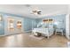 Charming bedroom with white four-poster bed, light wood floors, and French doors at 2037 Church Creek Pt, Largo, FL 33774