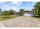 Paver driveway leads to a well-maintained home with a two-car garage, palm trees, and landscaped yard at 2037 Church Creek Pt, Largo, FL 33774
