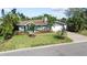Charming single-story home with a manicured lawn, lush landscaping, and a brick-paved driveway leading to the garage at 2037 Church Creek Pt, Largo, FL 33774