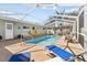 A clear in-ground pool with a screened in lanai, brick paver patio, and green back yard at 2037 Church Creek Pt, Largo, FL 33774