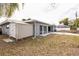 View of the backyard with a storage shed, sliding glass doors, and partial view of the white fence surrounding the pool at 2080 Attache Ct, Clearwater, FL 33764