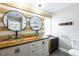 Contemporary bathroom with double glass vessel sinks and modern wooden accents at 2080 Attache Ct, Clearwater, FL 33764