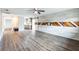 Spacious living room with wood-look floors, a modern ceiling fan, and accent wall at 2080 Attache Ct, Clearwater, FL 33764