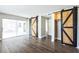 Living room with sliding doors to patio area and decorative barn-door closet at 2080 Attache Ct, Clearwater, FL 33764