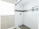 Bathroom shower featuring white subway tile and a decorative backsplash at 2080 Attache Ct, Clearwater, FL 33764