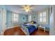 Cozy bedroom featuring hardwood floors, shutters, and a comfortable bed at 2505 W Morrison Ave, Tampa, FL 33629