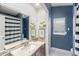 Stylish bathroom with a large mirror, decorative accents and shower/tub combo with blue accent wall at 2519 Southern Oak Cir, Clearwater, FL 33764