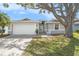 Charming single-story home with a well-manicured lawn and mature shade tree enhancing its curb appeal at 2519 Southern Oak Cir, Clearwater, FL 33764