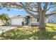 Single-story home showcasing lush palm trees, landscaped front yard, and a two-car garage at 2519 Southern Oak Cir, Clearwater, FL 33764