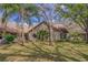 Scenic backyard featuring lush greenery, mature trees, and the rear facade of the home at 2847 Rampart Cir, Clearwater, FL 33761
