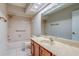 Bright bathroom with a large mirror, tiled shower/tub and a wood vanity at 2847 Rampart Cir, Clearwater, FL 33761