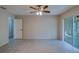 Bedroom featuring tile floors, access to bathroom and sunroom with a ceiling fan at 2847 Rampart Cir, Clearwater, FL 33761