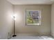A bright room with grey tile flooring with a window to the outside and a corner lamp at 2847 Rampart Cir, Clearwater, FL 33761