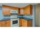 A kitchen is shown with oak cabinets, white appliances and a diamond-tiled backsplash at 2847 Rampart Cir, Clearwater, FL 33761