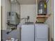 Functional laundry room with a washer, dryer, and water heater on elevated platform at 2847 Rampart Cir, Clearwater, FL 33761