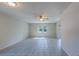 Spacious living area with neutral walls, tile floors, large window and ceiling fan with lighting at 2847 Rampart Cir, Clearwater, FL 33761
