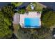 An aerial view of a community pool with lounge chairs surrounded by green landscaping at 2847 Rampart Cir, Clearwater, FL 33761