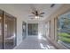 Bright and airy sunroom with ceiling fan, glass doors, tiled floors, and multiple windows at 2847 Rampart Cir, Clearwater, FL 33761