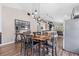 An open-concept dining area featuring a custom table, hardwood floors, and contemporary lighting at 31123 Stone Arch Ave, Wesley Chapel, FL 33545