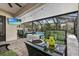 Relaxing screened patio with a fire pit, TV, comfortable seating, and a view of the sparkling pool at 31123 Stone Arch Ave, Wesley Chapel, FL 33545