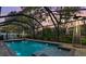 Sparkling pool surrounded by a screened enclosure and lush landscaping, perfect for outdoor enjoyment and privacy at 31123 Stone Arch Ave, Wesley Chapel, FL 33545