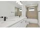 Bathroom with a double vanity, large mirror and shower with beige tile surround at 32335 Wetland Bird Vw, San Antonio, FL 33576