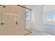 Modern bathroom featuring a frameless glass shower with marble tile and a view outside at 32335 Wetland Bird Vw, San Antonio, FL 33576
