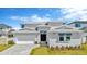 Elegant two-story home with a gray exterior, manicured lawn, and paved driveway leading to a two car garage at 32335 Wetland Bird Vw, San Antonio, FL 33576