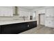Modern kitchen featuring a large center island, white cabinets, stainless steel appliances and wood flooring at 32335 Wetland Bird Vw, San Antonio, FL 33576