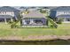 Aerial view of a private backyard featuring a screened-in patio, a pool, and a well-maintained lawn at 33899 Astoria Cir, Wesley Chapel, FL 33545