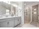 Clean bathroom featuring a double vanity with white countertops and glass-enclosed shower at 33899 Astoria Cir, Wesley Chapel, FL 33545