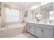 Bright bathroom with double vanity, garden tub, and decorative lighting at 33899 Astoria Cir, Wesley Chapel, FL 33545