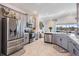 Modern kitchen with stainless steel appliances, gray cabinets, and a breakfast bar overlooking the living area at 33899 Astoria Cir, Wesley Chapel, FL 33545