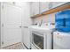 Functional laundry room with modern appliances, overhead cabinetry, and a neutral color scheme at 33899 Astoria Cir, Wesley Chapel, FL 33545