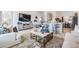 Comfortable living room with stylish furniture, a large TV, and an open layout to the kitchen and dining area at 33899 Astoria Cir, Wesley Chapel, FL 33545