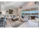 Bright living room featuring modern furnishings, stylish decor, and a view of the lake through large windows at 33899 Astoria Cir, Wesley Chapel, FL 33545