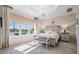 Main bedroom with tray ceiling, water view, and decorative chandelier at 33899 Astoria Cir, Wesley Chapel, FL 33545