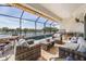 Inviting outdoor patio with comfortable seating, a dining table, and a summer kitchen overlooking a lake at 33899 Astoria Cir, Wesley Chapel, FL 33545