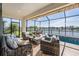 Inviting screened patio with comfortable seating, a dining area, and scenic lake views at 33899 Astoria Cir, Wesley Chapel, FL 33545