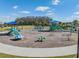 Community playground with slides, climbing structures, and shade canopies in a mulched area at 33899 Astoria Cir, Wesley Chapel, FL 33545